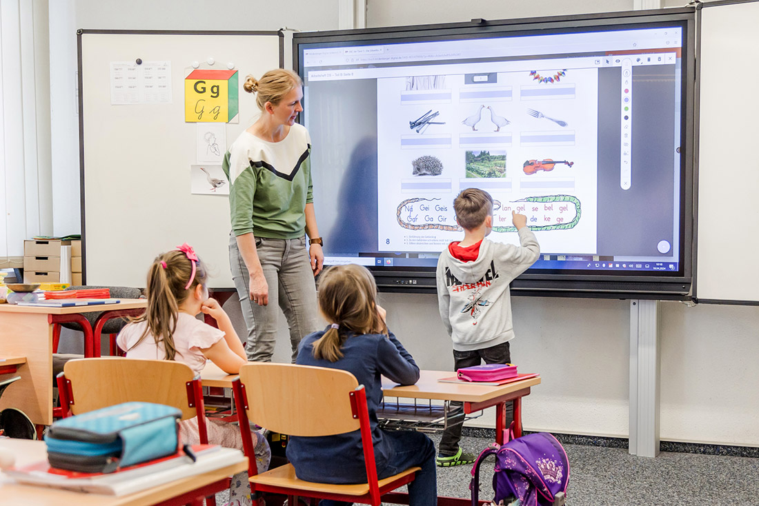 Schüler und Lehrerin vor Smartboard